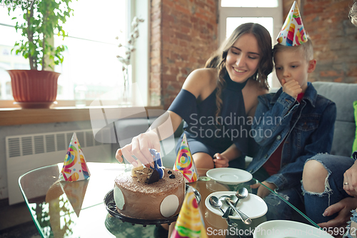 Image of Mother, son and sister at home having fun, comfort and cozy concept, celebrating birthday