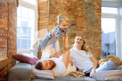 Image of Mother, father and son at home having fun, comfort and cozy concept