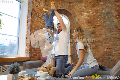 Image of Mother, father and son at home having fun, comfort and cozy concept