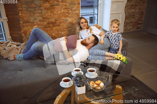 Image of Mother, father and son at home having fun, comfort and cozy concept