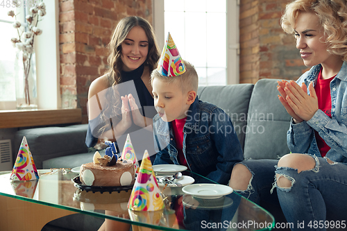 Image of Mother, son and sister at home having fun, comfort and cozy concept, celebrating birthday