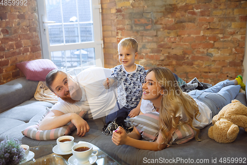 Image of Mother, father and son at home having fun, comfort and cozy concept