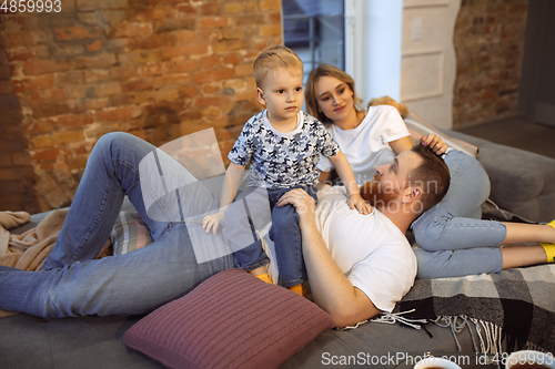 Image of Mother, father and son at home having fun, comfort and cozy concept