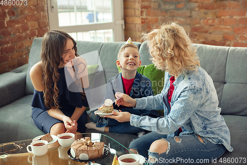 Image of Mother, son and sister at home having fun, comfort and cozy concept, celebrating birthday