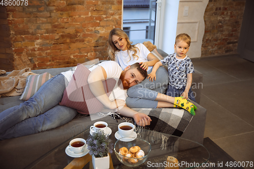 Image of Mother, father and son at home having fun, comfort and cozy concept