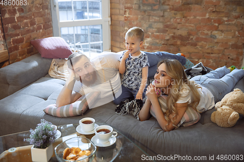 Image of Mother, father and son at home having fun, comfort and cozy concept