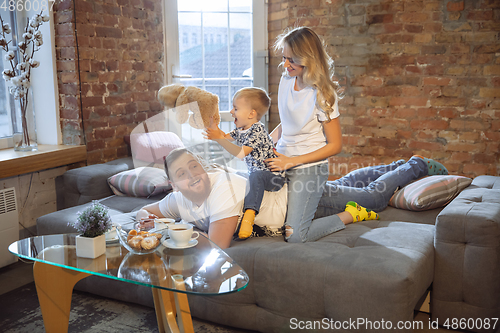 Image of Mother, father and son at home having fun, comfort and cozy concept