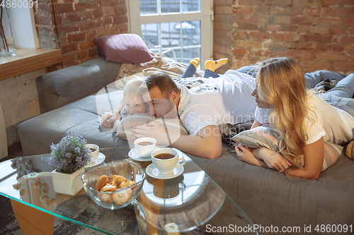 Image of Mother, father and son at home having fun, comfort and cozy concept