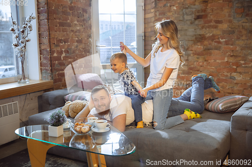 Image of Mother, father and son at home having fun, comfort and cozy concept