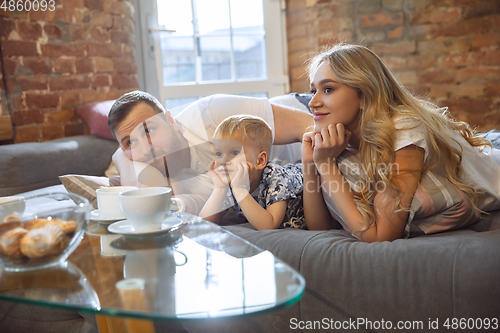 Image of Mother, father and son at home having fun, comfort and cozy concept