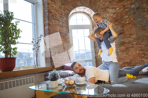 Image of Mother, father and son at home having fun, comfort and cozy concept