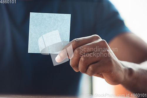 Image of Close up of african-american male hands, working in office