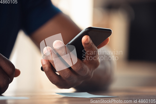 Image of Close up of african-american male hands, working in office