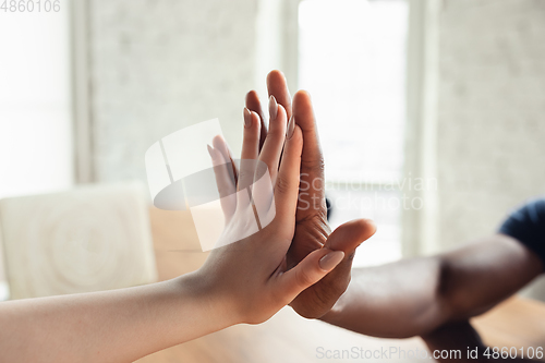 Image of Close up of african-american male and caucasian female hands, working in office