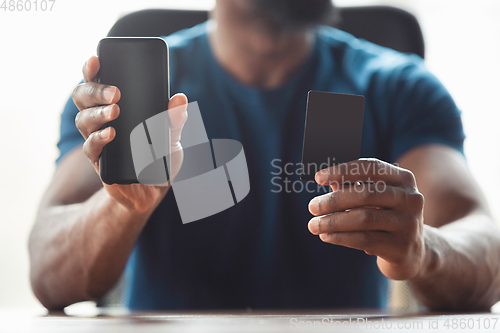 Image of Close up of african-american male hands, working in office