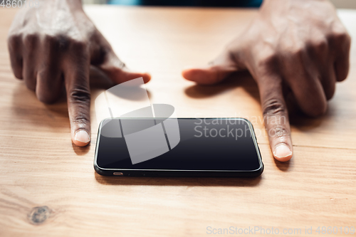 Image of Close up of african-american male hands, working in office