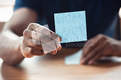 Image of Close up of african-american male hands, working in office