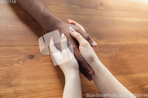 Image of Close up of african-american male and caucasian female hands holding