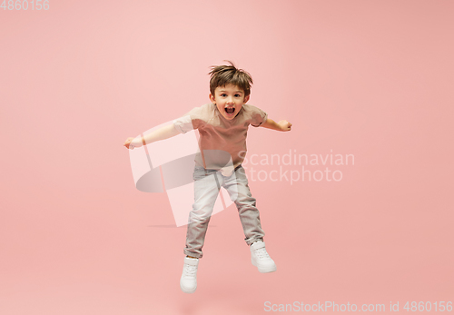 Image of Happy caucasian little boy isolated on pink studio background. Looks happy, cheerful, sincere. Copyspace. Childhood, education, emotions concept
