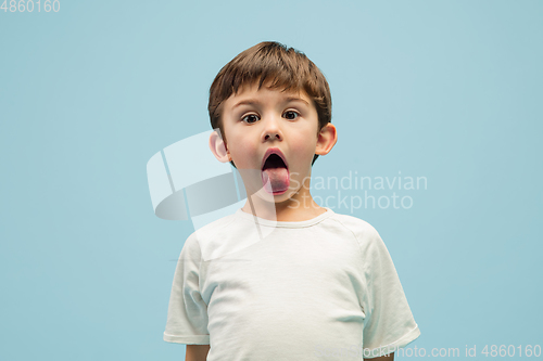 Image of Happy caucasian little boy isolated on blue studio background. Looks happy, cheerful, sincere. Copyspace. Childhood, education, emotions concept