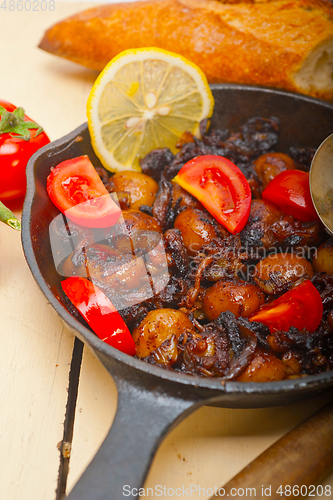 Image of Baby cuttle fish roasted on iron skillet