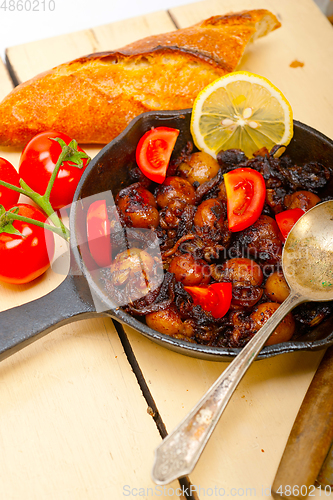 Image of Baby cuttle fish roasted on iron skillet