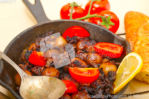 Image of Baby cuttle fish roasted on iron skillet