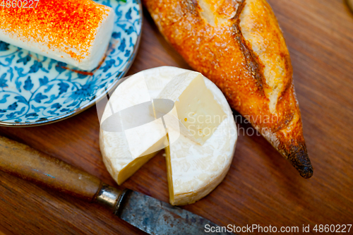 Image of French cheese and fresh  baguette on a wood cutter