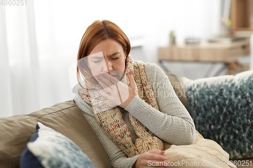 Image of sick woman in scarf coughing at home