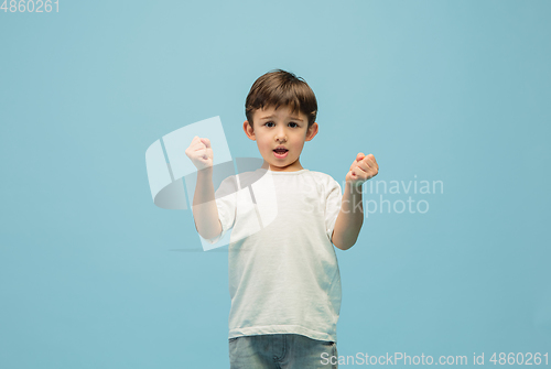 Image of Happy caucasian little boy isolated on blue studio background. Looks happy, cheerful, sincere. Copyspace. Childhood, education, emotions concept