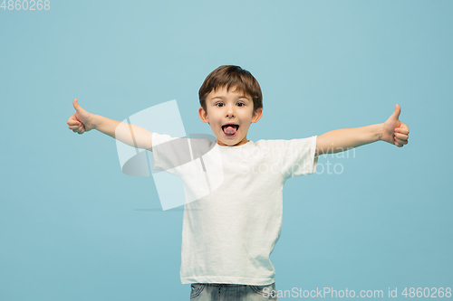 Image of Happy caucasian little boy isolated on blue studio background. Looks happy, cheerful, sincere. Copyspace. Childhood, education, emotions concept