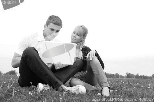 Image of young man and girl blonde with laptop