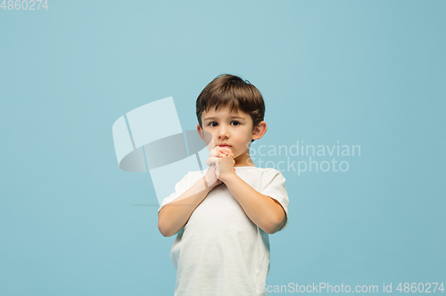 Image of Happy caucasian little boy isolated on blue studio background. Looks happy, cheerful, sincere. Copyspace. Childhood, education, emotions concept