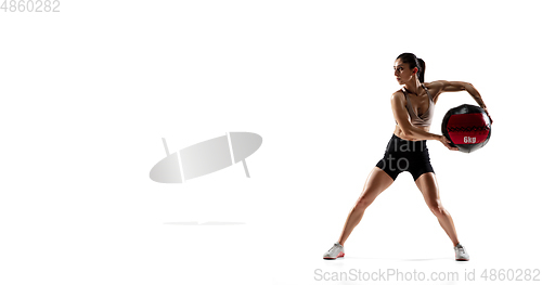 Image of Caucasian professional female athlete training isolated on white studio background. Muscular, sportive woman.