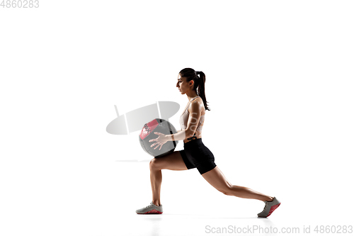 Image of Caucasian professional female athlete training isolated on white studio background. Muscular, sportive woman.