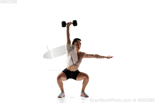 Image of Caucasian professional female athlete training isolated on white studio background. Muscular, sportive woman.