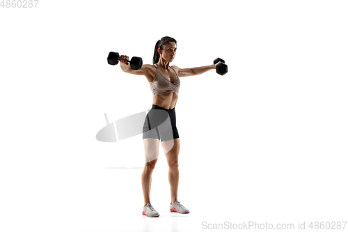 Image of Caucasian professional female athlete training isolated on white studio background. Muscular, sportive woman.