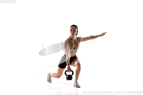 Image of Caucasian professional female athlete training isolated on white studio background. Muscular, sportive woman.