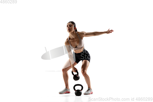 Image of Caucasian professional female athlete training isolated on white studio background. Muscular, sportive woman.