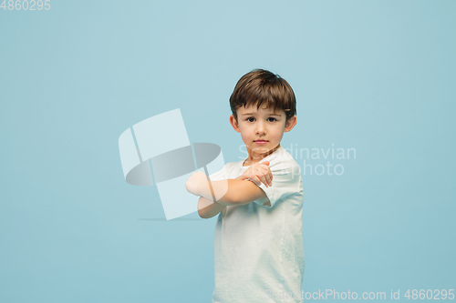 Image of Happy caucasian little boy isolated on blue studio background. Looks happy, cheerful, sincere. Copyspace. Childhood, education, emotions concept