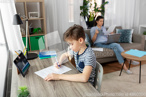 Image of student boy with tablet computer learning at home