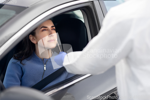 Image of healthcare worker making coronavirus test at car