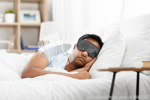 Image of indian man in eye mask sleeping in bed at home