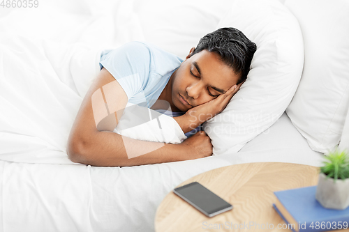 Image of indian man sleeping in bed at home