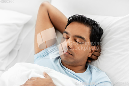 Image of indian man sleeping in bed at home