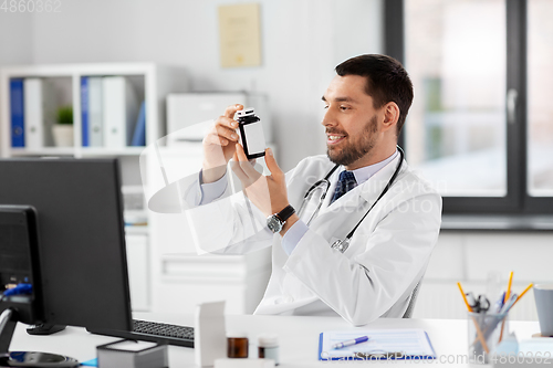 Image of smiling male doctor with medicine at hospital