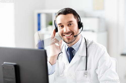 Image of happy doctor with computer and headset at hospital