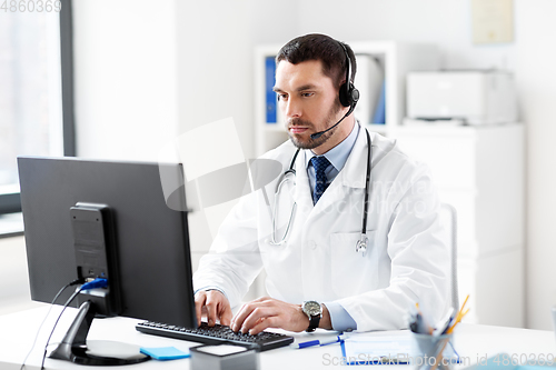 Image of male doctor with computer and headset at hospital