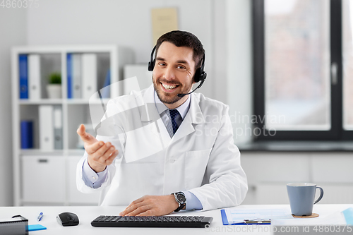 Image of male doctor in headset having video call at clinic