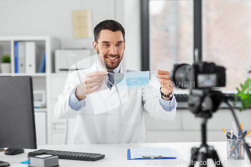 Image of doctor with mask recording video blog at hospital